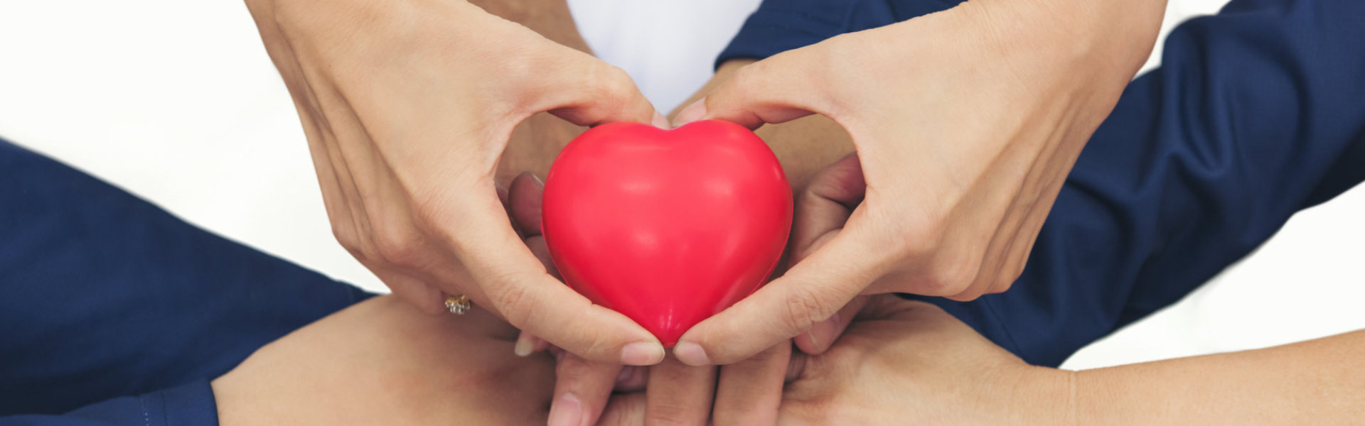 group of people holding a heart